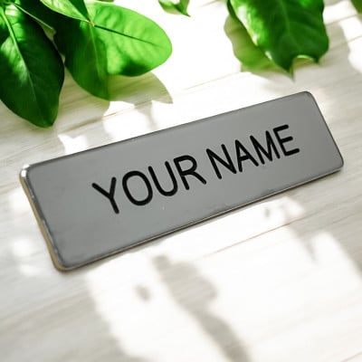 Silver engraved metal uniform name tag with crisp black engraved lettering